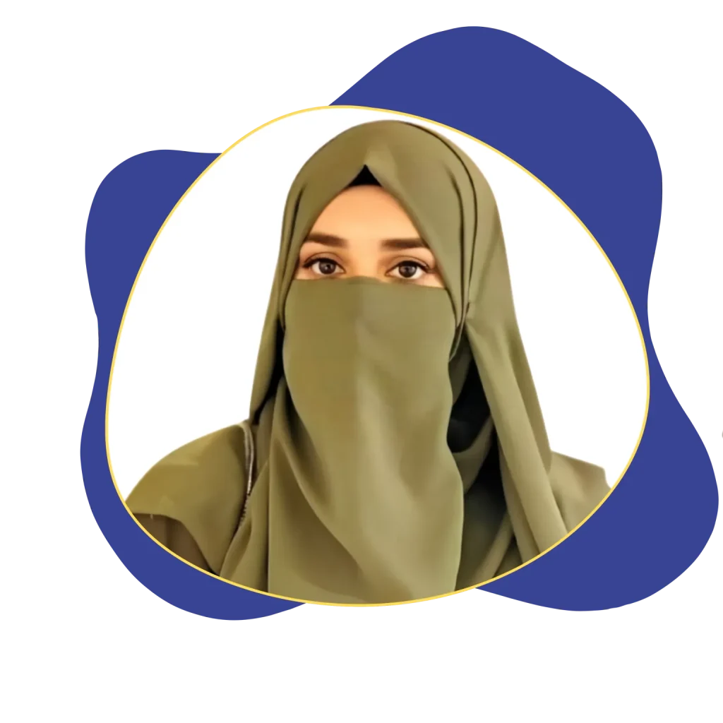 A portrait of a focused woman with red hair in a ponytail and round glasses, wearing a mustard-yellow shirt, working on a silver laptop in a bright office environment.